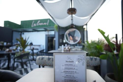a sign in front of a restaurant with tables and chairs at Hotel SRR Grand in Chennai