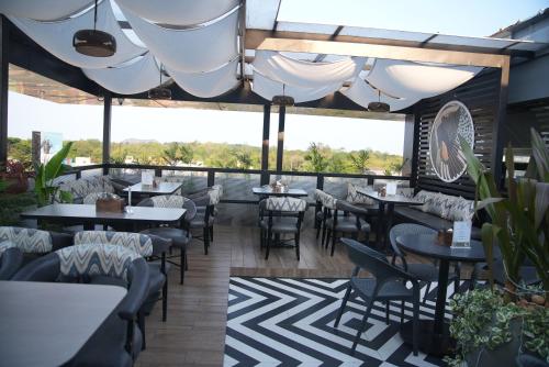 restauracja ze stołami i krzesłami na patio w obiekcie Hotel SRR Grand w mieście Ćennaj