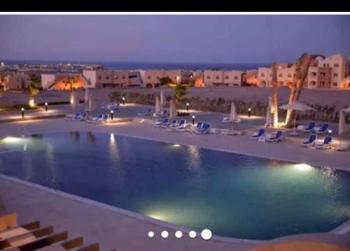 a large swimming pool with chairs and a resort at 1-Bed property in Makadi Heights in Hurghada