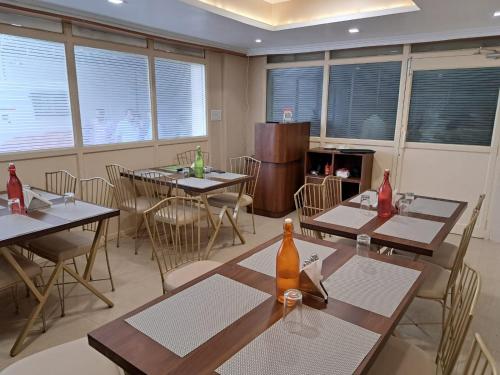 a dining room with tables and chairs and windows at Hotel MK Grand in Varanasi