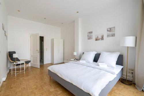 a white bedroom with a large bed and a desk at Vienna Central Panorama in Vienna