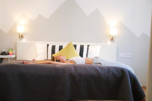 a woman laying on a bed with a pillow at Hotel Saalbacher Hof in Saalbach Hinterglemm