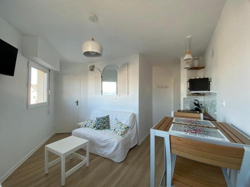 a living room with a couch and a table at Studio vue mer face à la plage in Plougonvelin