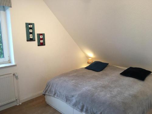 - une chambre avec un lit et 2 oreillers dans l'établissement Urlaubsfeeling-in-der-Captains-Suite-App-18, à Timmendorfer Strand