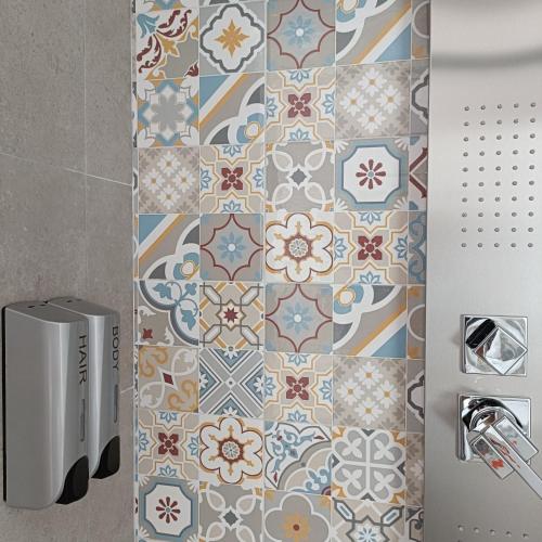 baño con pared de azulejos y radiador en Living Castro Apartments, en Castro di Lecce