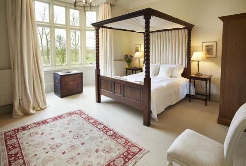 a bedroom with a canopy bed and a large window at The Old Rectory - Norfolk in North Tuddenham