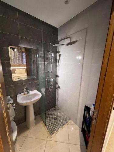 uma casa de banho com um chuveiro, um lavatório e um WC. em Appartement la Ville Haute em Kenitra