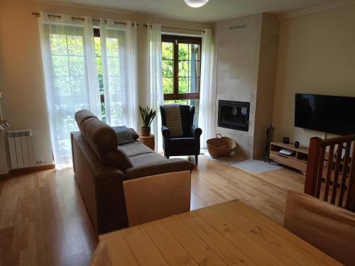 a living room with a couch and a television at Dúplex en Valencia d'Àneu (Baqueira Beret) in Valencia de Aneu