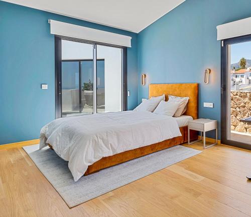 ein Schlafzimmer mit einem großen Bett mit blauen Wänden in der Unterkunft Luxury stay in Villa Capellania. in Benalmádena