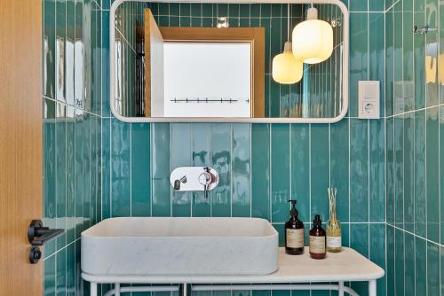 ein Badezimmer mit einem weißen Waschbecken und grünen gefliesten Wänden in der Unterkunft Luxury stay in Villa Capellania. in Benalmádena