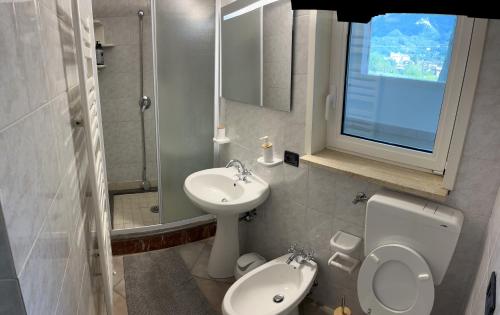 a bathroom with a toilet and a sink at Villa Belvedere Versilia - Villa con tre camere, cucina, sala, giardino con piscina e vista - 7 posti letto in Camaiore