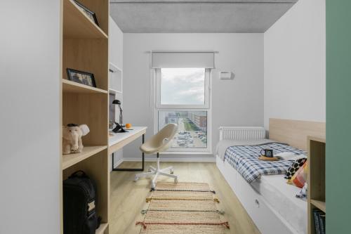 um quarto com uma cama, uma secretária e uma cadeira em Apartamenty Depot Wróblewskiego em Lódź