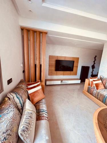 a living room with a couch and a flat screen tv at Appartement la Ville Haute in Kenitra