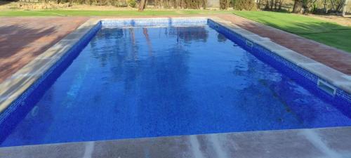 uma piscina com água azul num quintal em Casa La Masía de Córdoba em Almedinilla