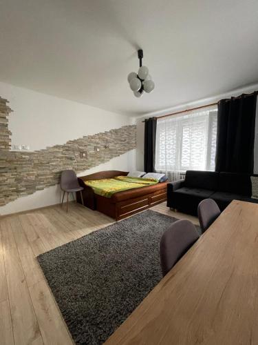 a living room with a bed and a couch at Apartament na Piaskach in Ostrowiec Świętokrzyski