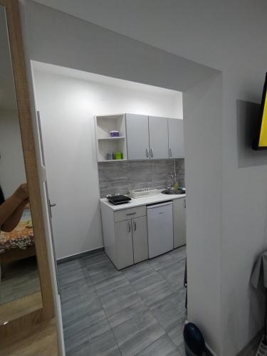 una piccola cucina con mobili bianchi e un lavandino di Pavicevic a Soko Banja