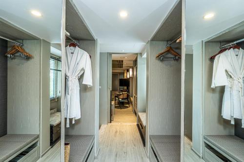 a walk in closet with white clothes on racks at Layana Resort & Spa - Adult Only - SHA Extra Plus in Ko Lanta