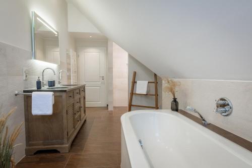 a bathroom with a bath tub and a sink at Villa Agni in Dänschendorf