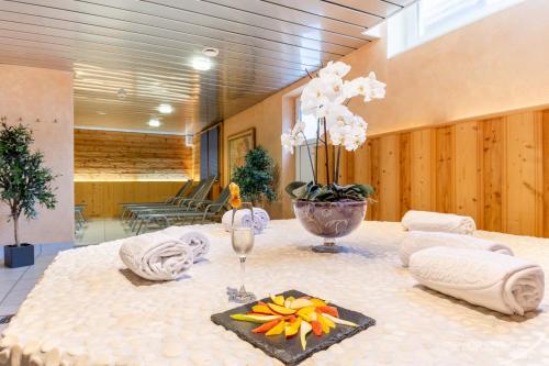 a table with towels and a vase of flowers on it at Turmhotel Victoria Davos in Davos