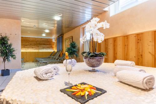 a table with towels and a vase of flowers on it at Swiss Quality Turmhotel Victoria in Davos