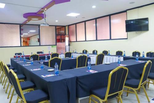 a conference room with a long table with blue tables and chairs at Two Oceans Hotel Voi in Voi