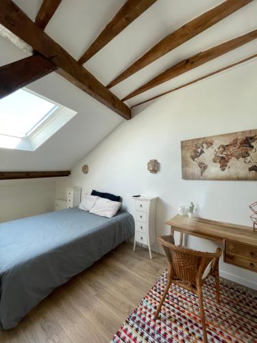 a bedroom with a bed and a desk and a table at LA CHOUETTE DU LAC MARION in Biarritz