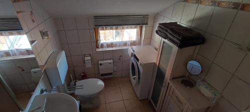 a small bathroom with a toilet and a sink at Schöne helle Ferienwohnung in Eurasburg