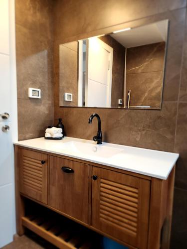 W łazience znajduje się umywalka i lustro. w obiekcie לוויס פלייס levis place 52 w Ejlat