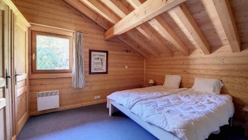a bedroom with a bed in a log cabin at Chalet MON FRERE in Le Biot