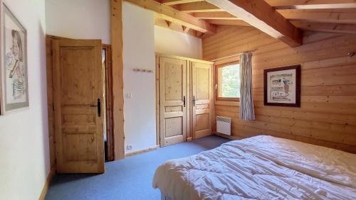 a bedroom with a bed in a wooden cabin at Chalet MON FRERE in Le Biot