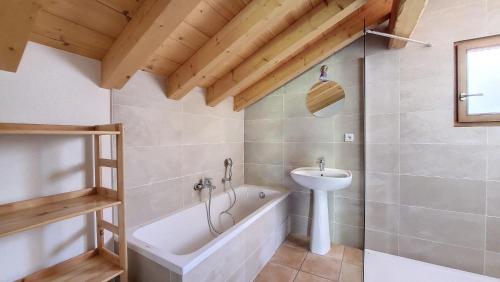 y baño con bañera y lavamanos. en Chalet MON FRERE en Le Biot