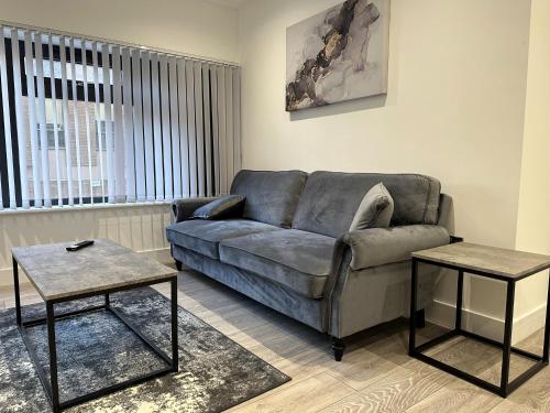 a living room with a couch and two tables at Apartment In Luton Town Centre in Luton