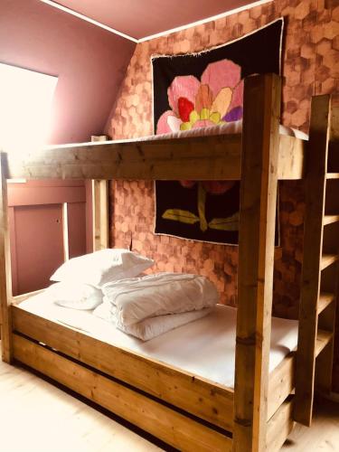 a wooden bunk bed in a room with a wall at Slapen bij de Brug in Zuidveld