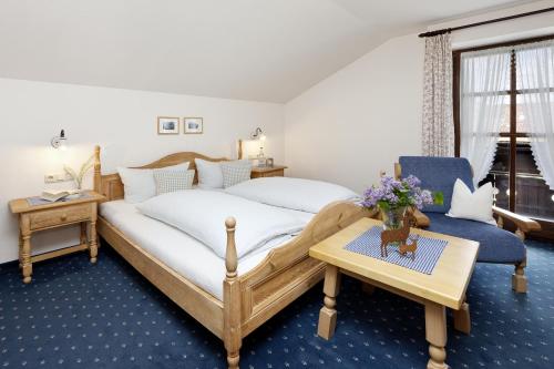 a bedroom with a bed and a table and a chair at Haus Vogler in Oberstdorf