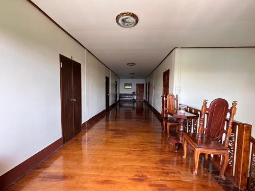 a hallway with wooden floors and chairs and a clock on the ceiling at กาลครั้งหนึ่ง ณ เชียงคาน (Once Upon A time) in Chiang Khan
