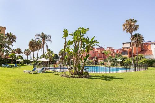 a resort with a swimming pool and palm trees at Exclusive Alamos Beach in Torremolinos