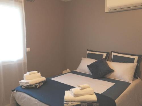 une chambre avec deux lits avec des serviettes dessus dans l'établissement MAISON DU BONHEUR, à Lesparre-Médoc