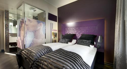 a bedroom with two beds and a purple wall at Hotel Oleana in Bergen