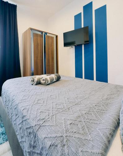 a bedroom with a large bed with blue and white sheets at Intimate Studios Hadersdorf in Hadersdorf am Kamp