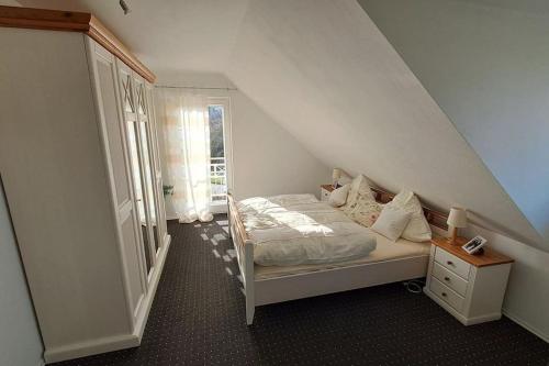 a small bedroom with a bed and a staircase at Mawo Lodge in Lohfelden