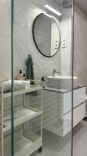 a white bathroom with a sink and a mirror at Linden Apartman 001 - Adults Only in Mosonmagyaróvár