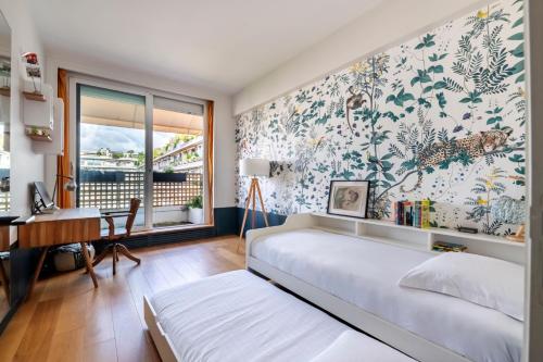 a bedroom with a bed and a desk and a window at Veeve - Eiffel Exuberance in Paris