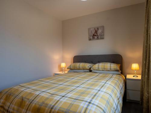 a bedroom with a bed with two night stands and two lamps at Hawthorn Cottage in Richmond