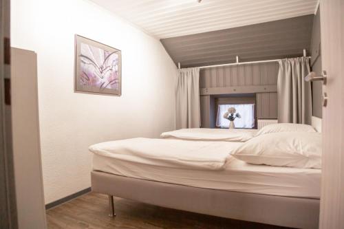 ein Schlafzimmer mit einem großen weißen Bett in einem Zimmer in der Unterkunft Ferienhaus Meier in Eschweiler