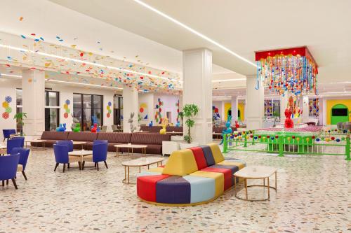a large lobby with colorful chairs and tables at Neverland City Hurghada - Pickalbatros in Hurghada
