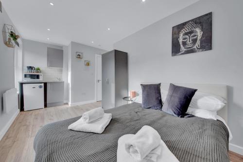 a bedroom with a large bed with towels on it at Lovely 1-Bed Studio in West Drayton in West Drayton