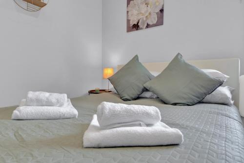a white bed with white towels on top of it at Captivating 1-Bed Studio in West Drayton in West Drayton