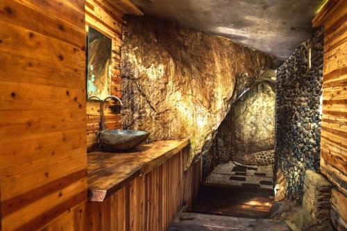 a bathroom with a sink and a stone wall at Ricky's Beach House in Pasarsungai-nyala