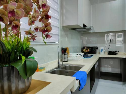 a kitchen with a sink and a vase with flowers at 2 Seaview Balcony@Danga Bay in Johor Bahru