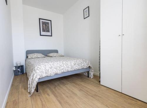 オルリーにあるAppartement 450 m gare RER Cのベッドと木の床のある寝室